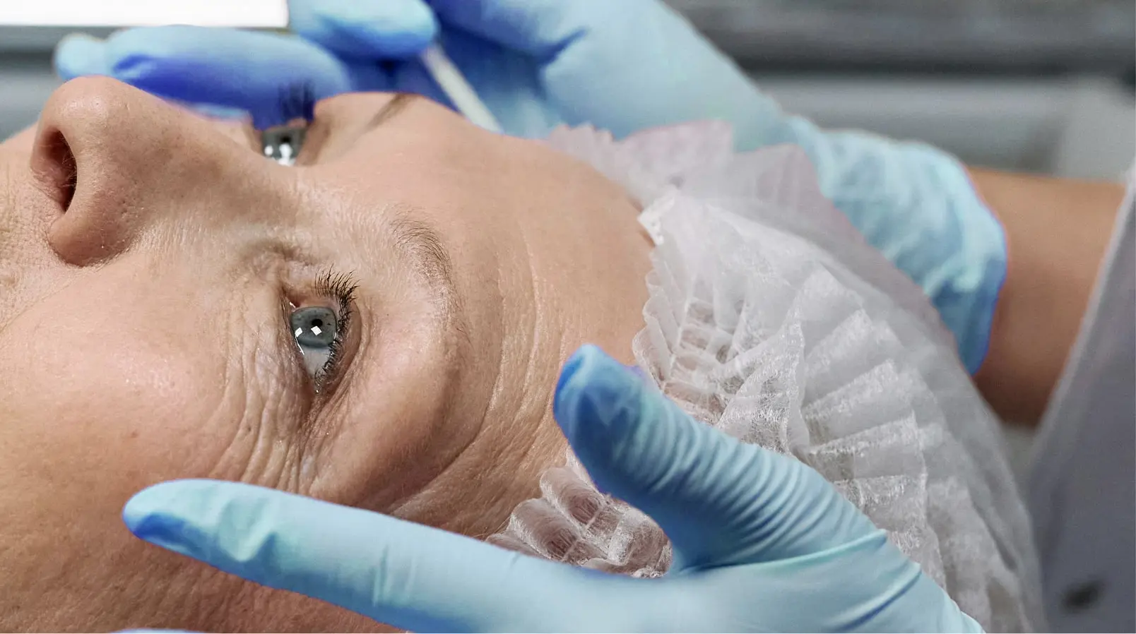 Ophtalmologue qui s'apprête à réaliser des soins esthétiques anti-âge autour des yeux.